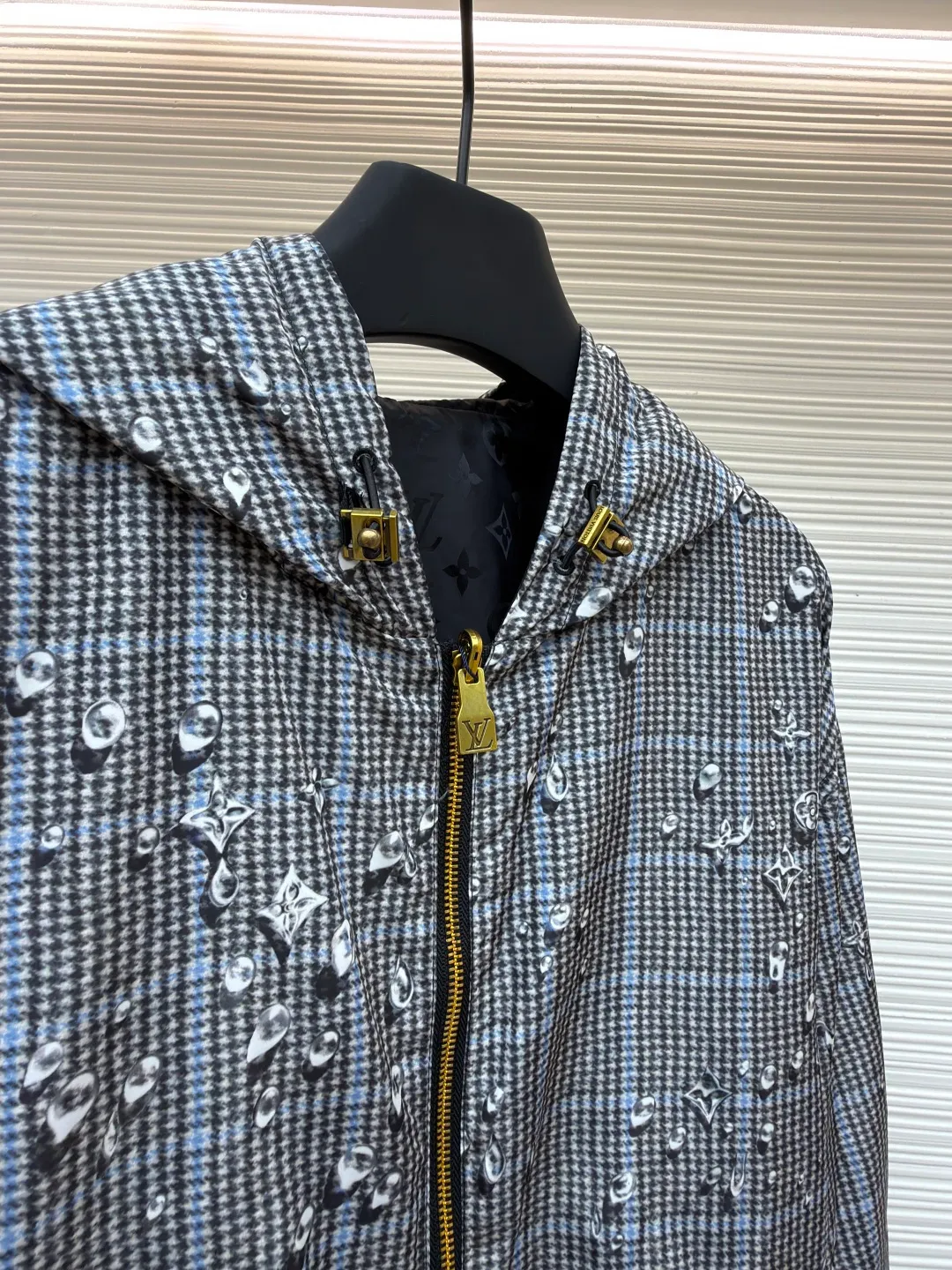 LOUIS VUITTON double-sided hooded raindrop printed windproof jacket ●Original version: 23999 purchase and development ●Item number: 1681911-B40 ●Fabric: nylon fabric ●Technology: printing production ●Color: gray ●Version: fitted version ●Weight: about 460 grams ●Size: S-M-L-XL ●Description: This lightweight double-sided windproof jacket presents two different styles: a vivid Monogram Waterdrop on one side The print consists of playful Monogram logos raining down on elegant Prince of Wales check. The other side is a timeless dark color, complemented by a subtle monogram jacquard in the same color. Easy to store, it's the perfect choice for a cozy weekend in the countryside or a rainy stroll in the city. Body: 100% polyester; Lining: 100% nylon; Other: 100% cotton, Drawstring hood Elasticized cuffs and hem Logo printed at outer side, jacquard logo pattern at inner side Zip at front Trim pockets. The overall wiring is straight and delicate, the fabric is comfortable and soft, and the color is consistent without color difference. It can be matched with the same style to create a fashionable look and control various occasions. Customized accessories, complete with three standards, same style for men and women!